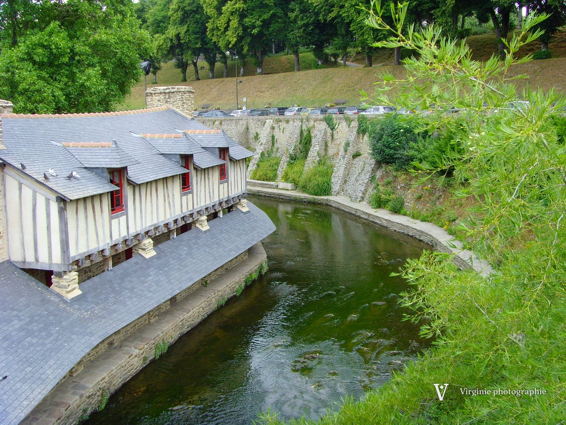 Un long lavoir couvert au bord d’un canal vert