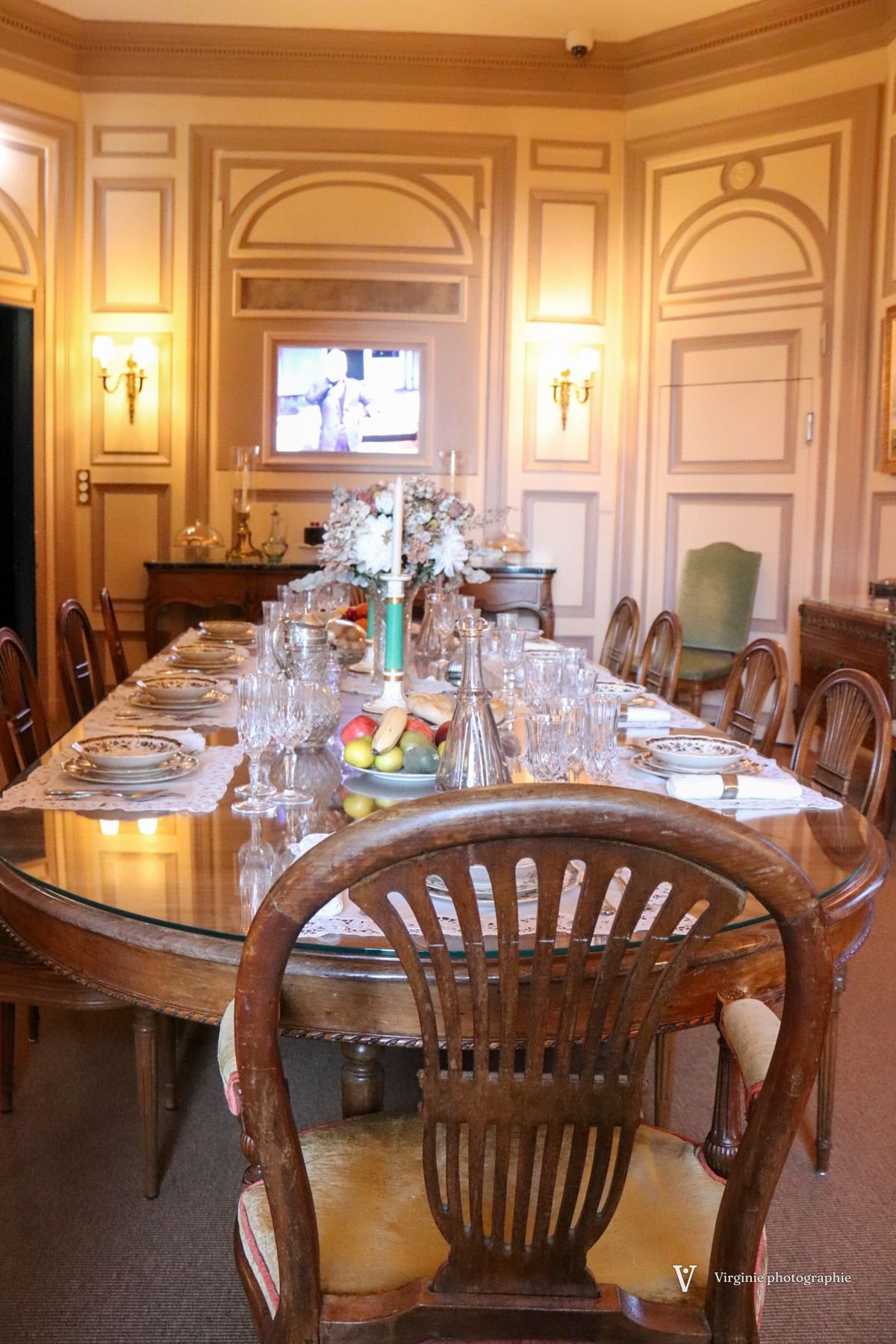 Une grande table dressée dans une salle à manger lambrissée