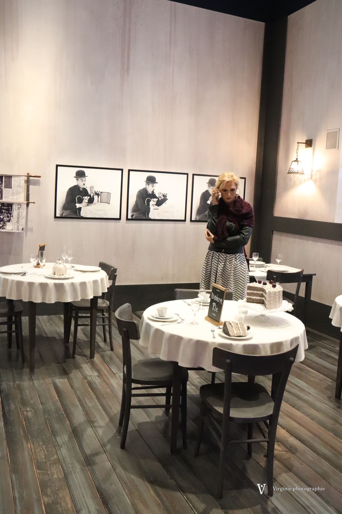Des tables nappées de blanc sous des photos en noir et blanc