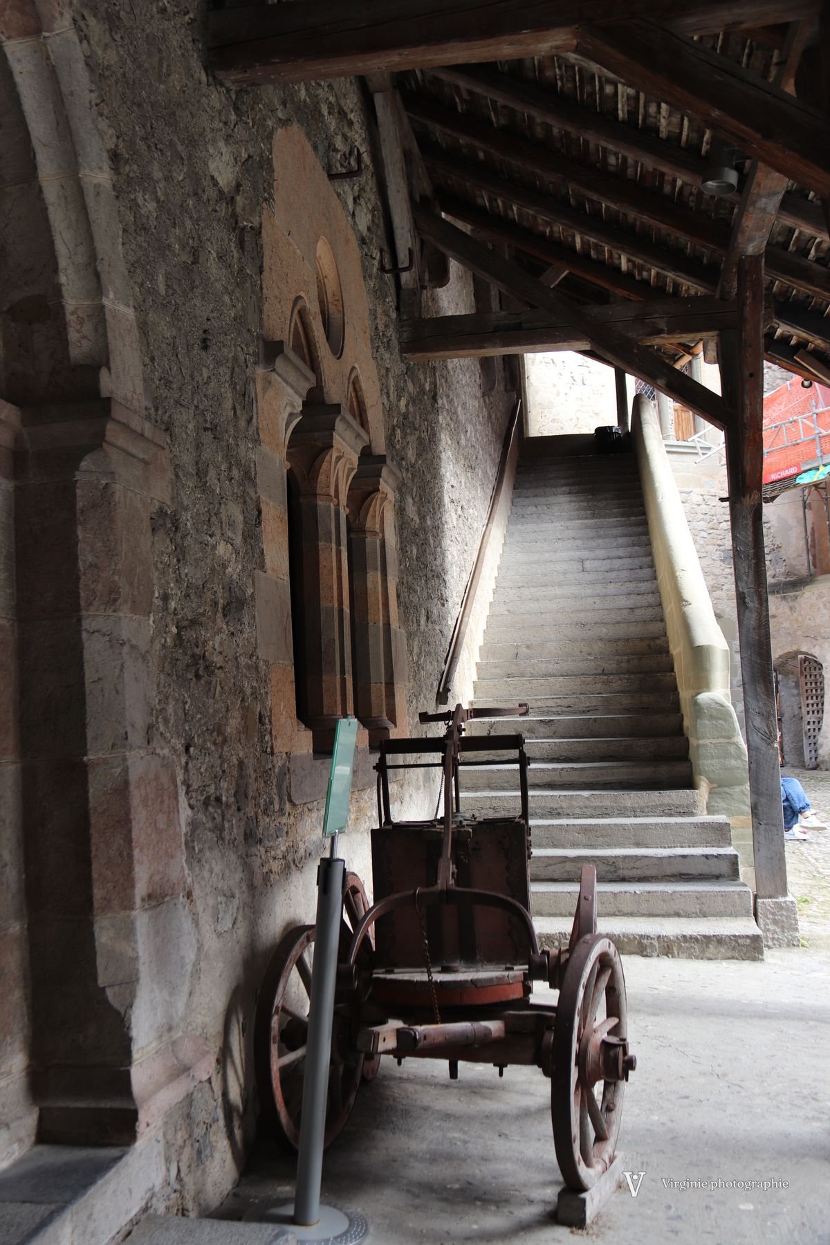 Une vieille charrette au pied d’un escalier couvert