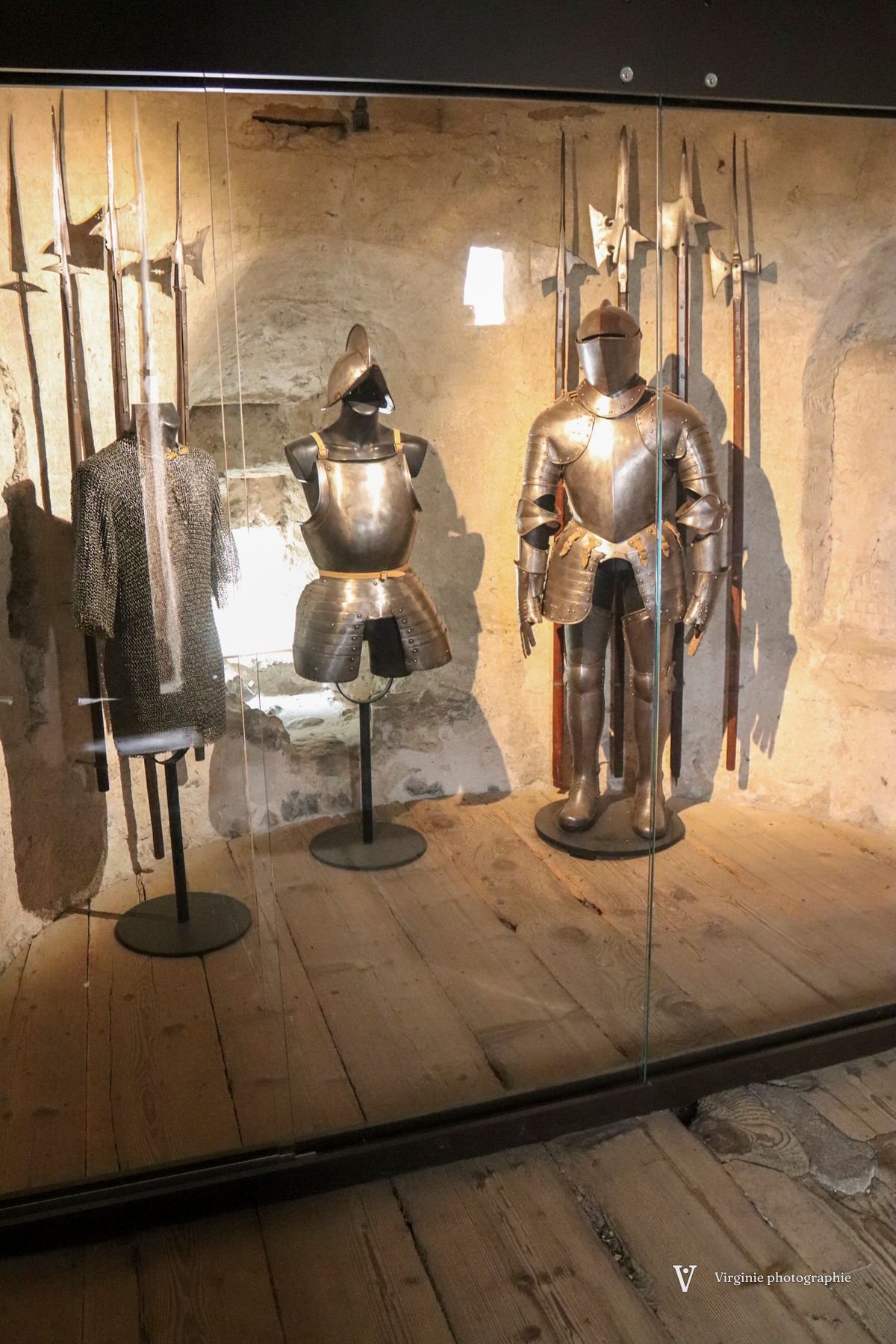 Des armures et des hallebardes exposées dans une vitrine