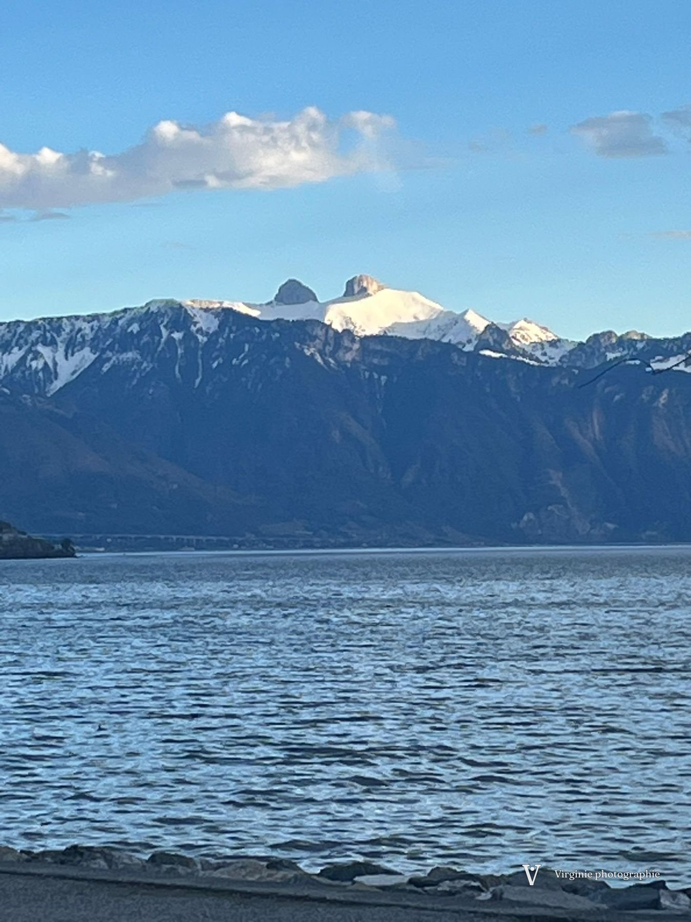 Des sommets enneigés au-dessus du lac, sous un ciel bleu
