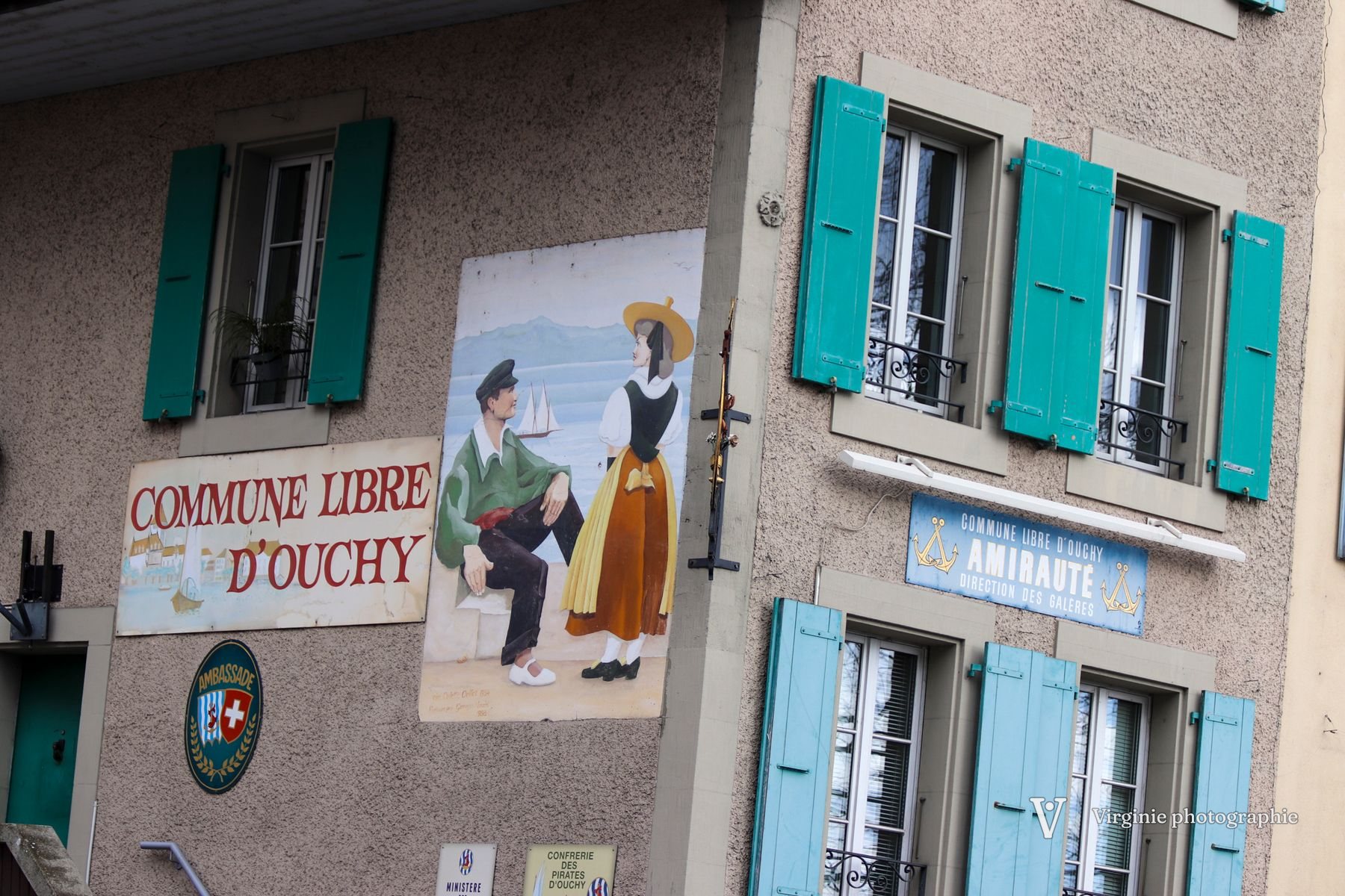Une façade aux volets turquoise peinte d’une scène folklorique